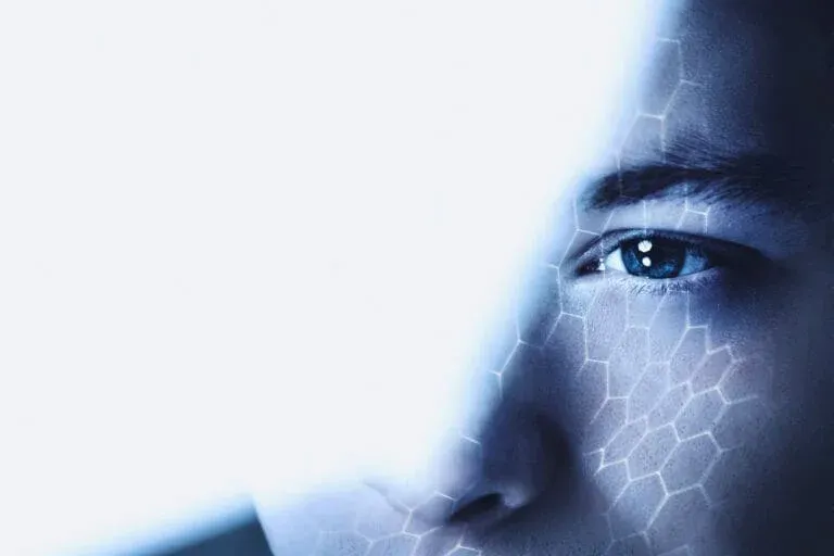 A man looking through glass at a digital display, representing the human factor in cybersecurity