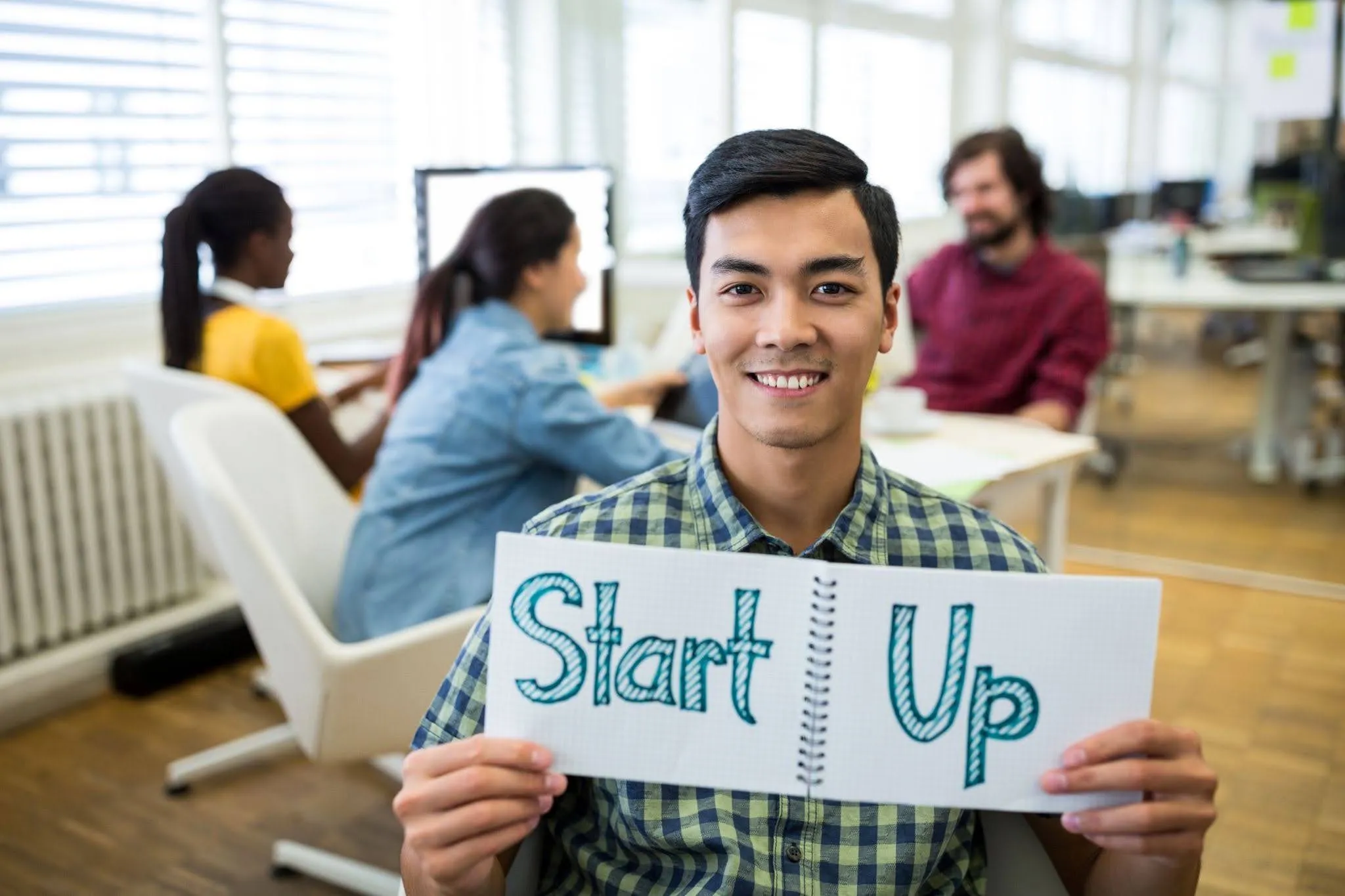 Startup founder holding a sign while exploring funding for a new business